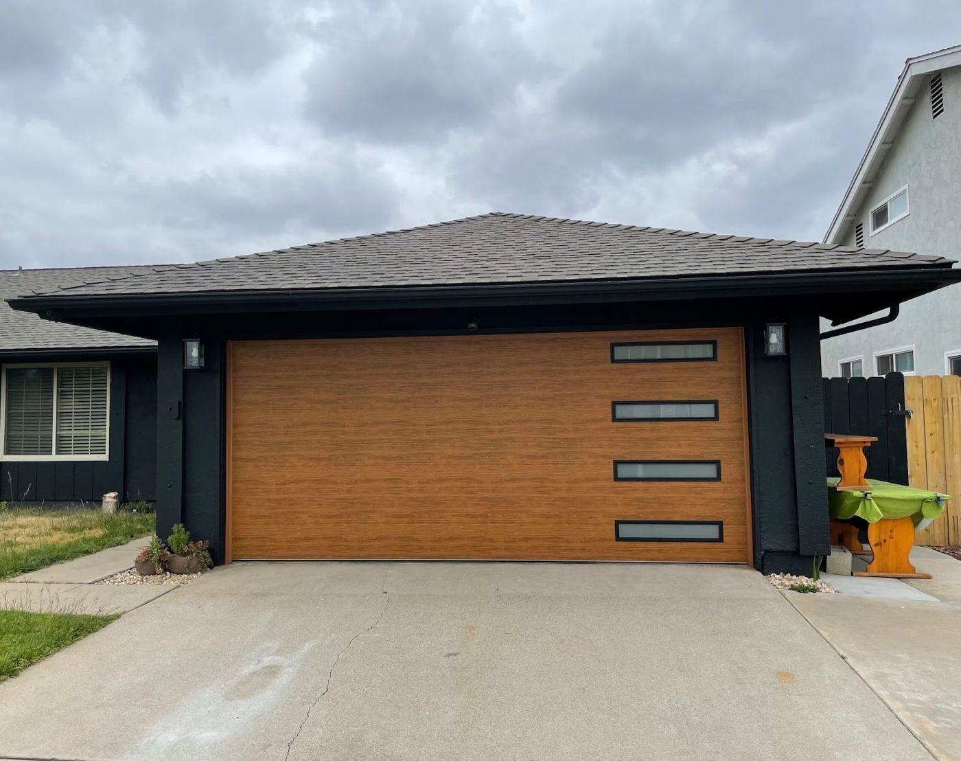Golden wood-look garage door on a dark-trim home